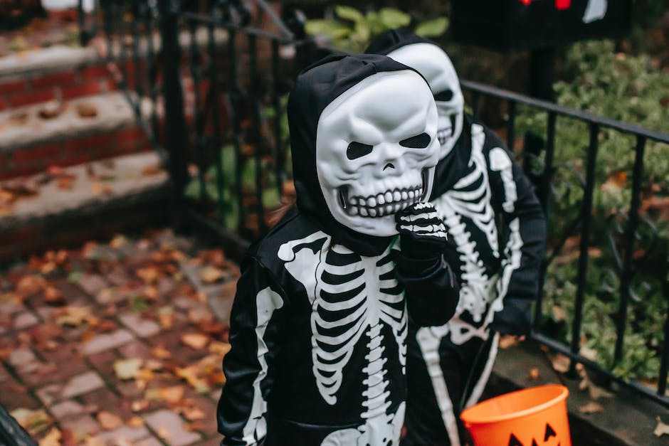  Kinder feiern Halloween aus einer Kostümparade und Süßigkeiten sammeln